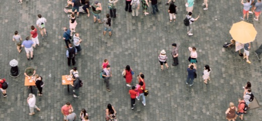 An aerial view of a group of people walking across a cobbled street